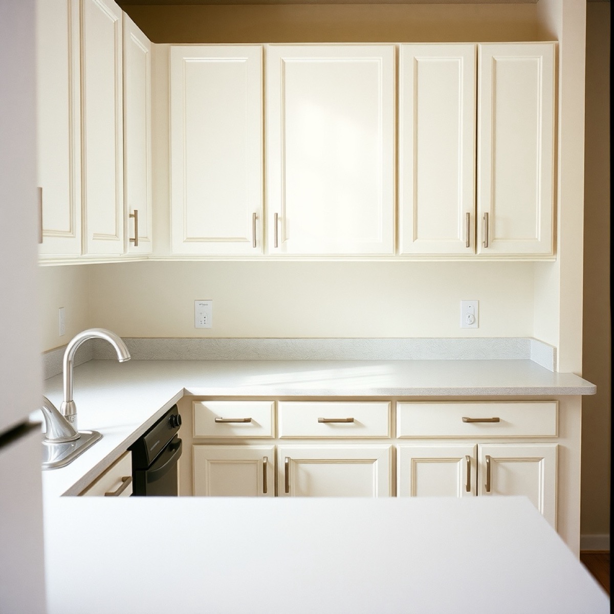 White shaker cabinets with quartz countertops in an apartment kitchen, placeholder photo